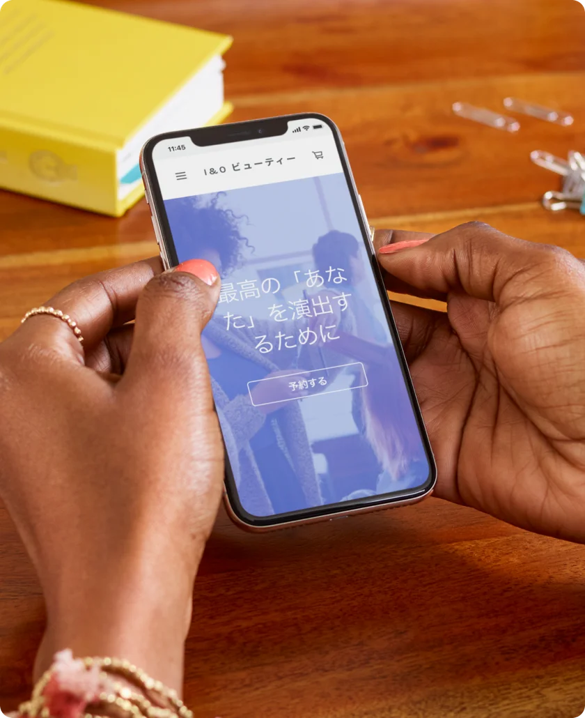 Square公式掲載写真。スマートフォンにI＆O ビューティーの紹介ページと「予約する」ボタンが表示されている。